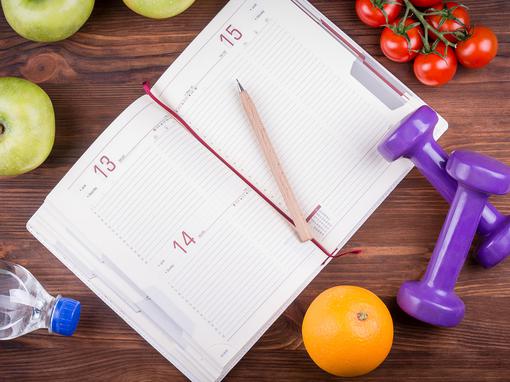 Wooden,Table,With,A,Notepad,,Pen,,Dumbbells,Bottle,Of,Water