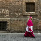 A Catholic bishop walks in a back street in Rome