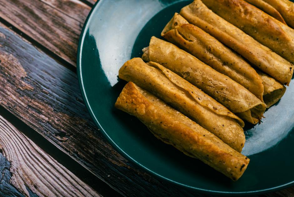 Tacos flauta on a wooden table. Mexican snacks. | Author: Sandor