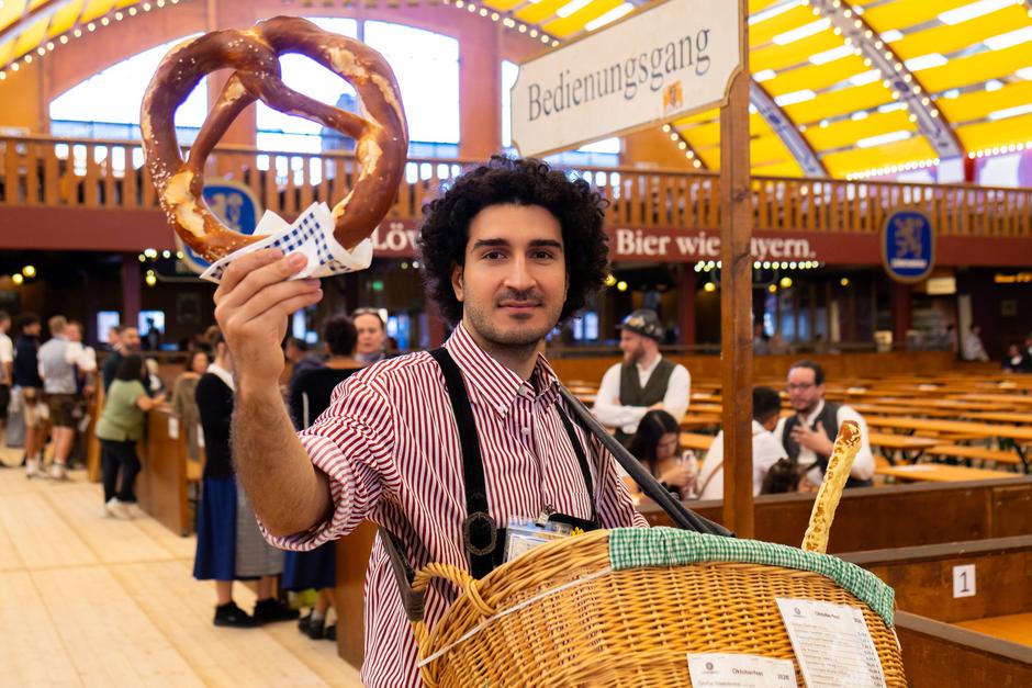 Munich, Bavaria, Germany September 19, 2026: A pretzel vendor offers large Wiesn pretzels from a carrying basket in the | Author: Profimedia