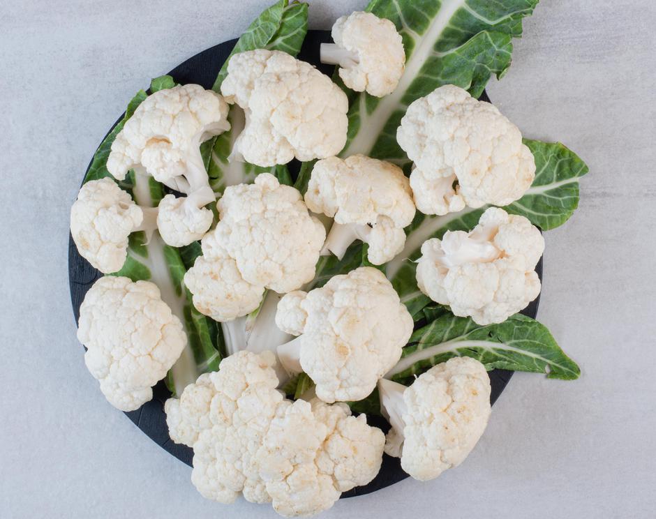 Sliced fresh cauliflower with leaves on black board | Author: azerbaijan_stockers / Freepik