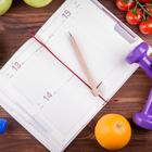 Wooden,Table,With,A,Notepad,,Pen,,Dumbbells,Bottle,Of,Water