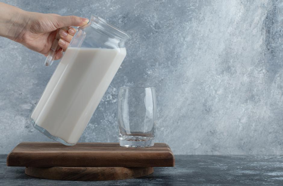 Female hands holding jug of milk on marble background | Author: azerbaijan_stockers / Freepik