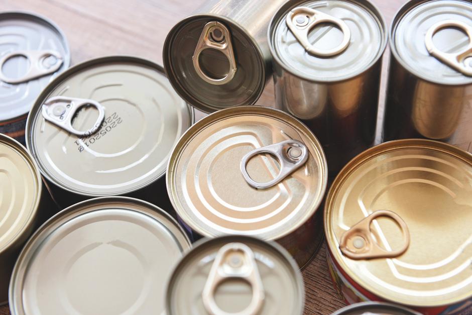 Various canned food in metal cans on wooden background , top vie | Author: Vecteezy
