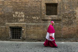 A Catholic bishop walks in a back street in Rome