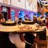 Munich, Bavaria, Germany September 19, 2026: A waiter carries several trays of food through a crowded festival tent at t