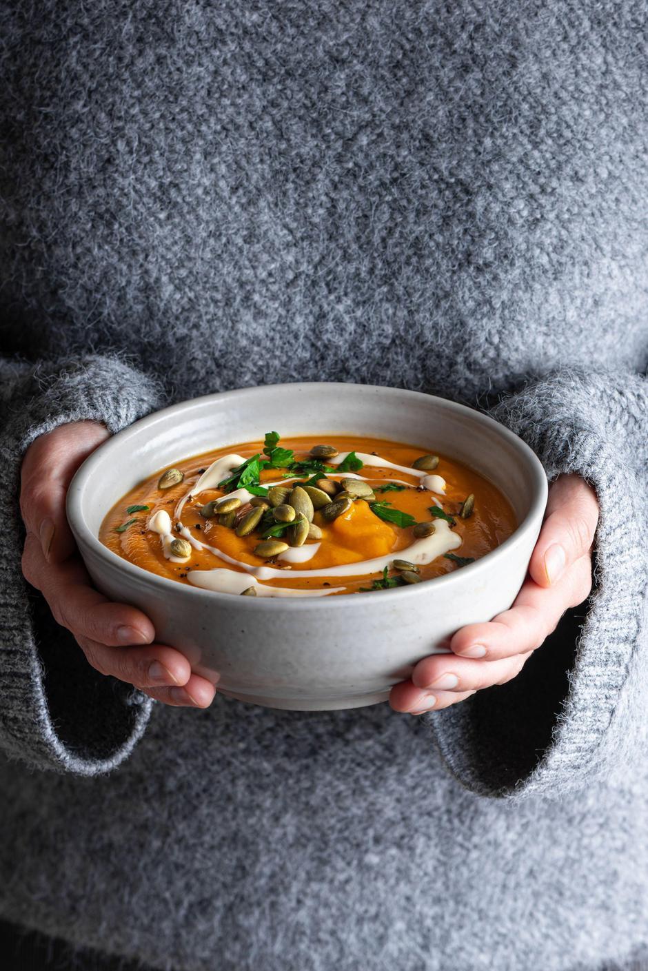 Bowl of autumn warming pumpkin soup in female hands in gray knitted sweater as background. Autumn cozy meal, seasonal comfort food concept. Healthy ea | Author: Profimedia