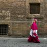 A Catholic bishop walks in a back street in Rome